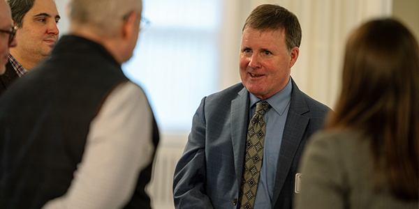 Sean Reynolds talking with staff at winter luncheon