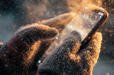 gloved hands holding a mobile phone