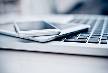 picture of cell phones lying on top of a laptop