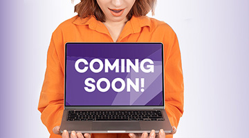 Person holding a laptop with the words "Coming Soon" onscreen
