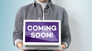 Person holding a laptop with the words "Coming Soon!" onscreen