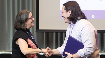 Miriam Shapiro, associate provost for undergraduate education at Northwestern, presents Connor Bain, assistant professor of instruction, computer science, McCormick School of Engineering and Applied Science with his "Most Innovative Course Site" certificate